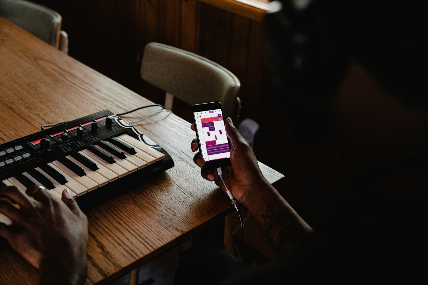 Een muziekmaker werkt met een keyboard en een mobiele opname-app