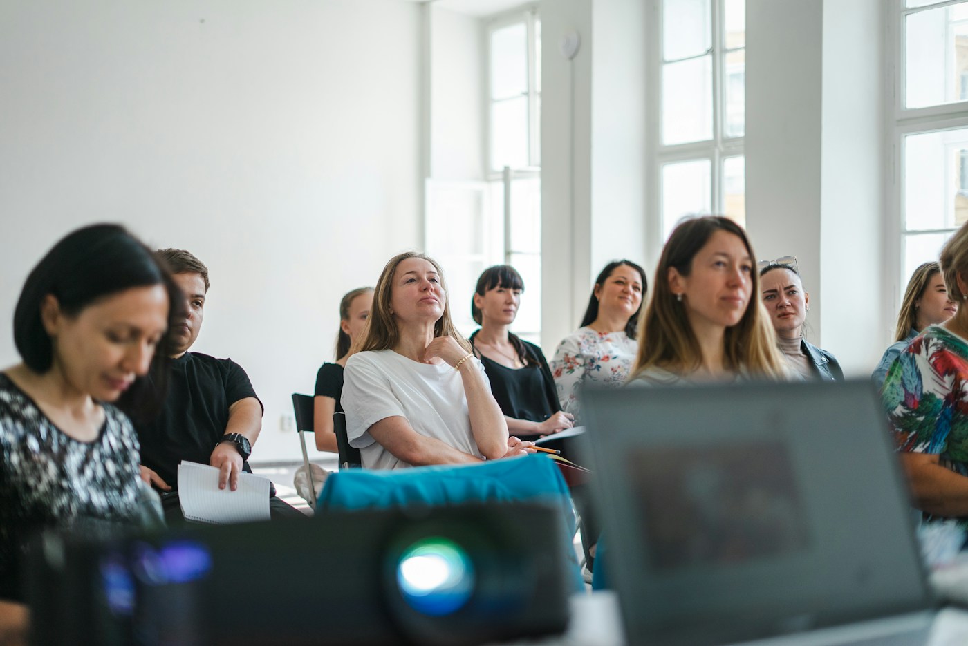 Deelnemers luisteren en leren in een gezamenlijke sessie